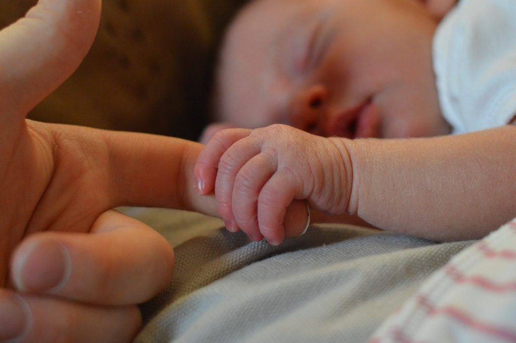Bébé tenant la main de son parent